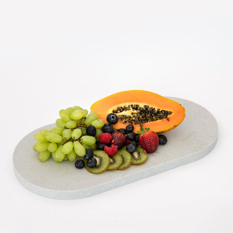 Double arch quartz serving platter in Caesarstone Airy Concrete™ created by Aureliia Collection. Similar to a marble platter, the Double arch quartz food platter shown with fresh fruit - blueberries, papaya, raspberries, strawberries and kiwi fruit. An excellent home decor gift for someone who has it all.