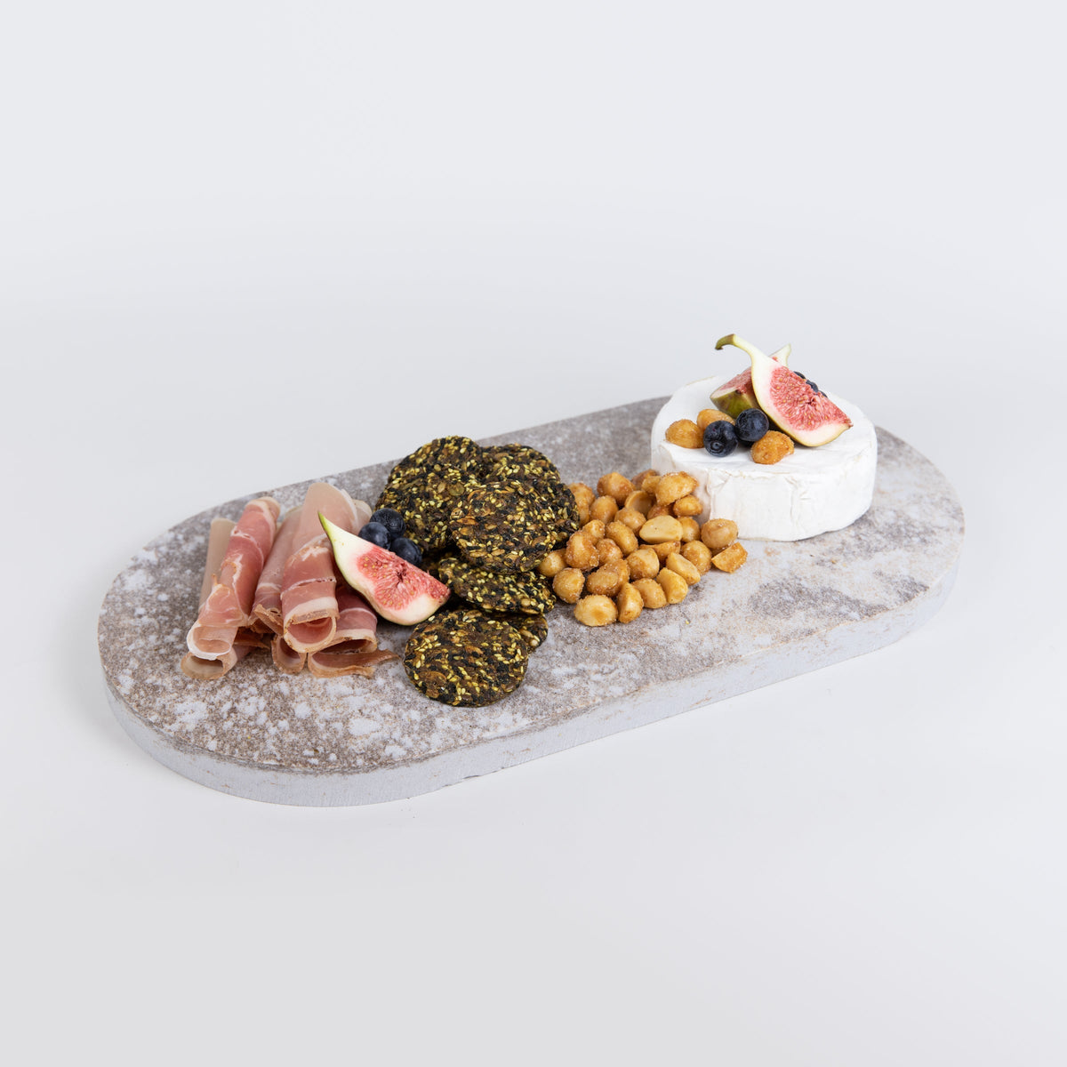 Double arch quartz platters in Caesarstone Excava™ created by Aureliia Collection. The Double arch quartz cheese boards shown with soft cheese, honey roasted macadamia nuts, prosciutto and grain crackers. An excellent home decor gift for someone who has it all.
