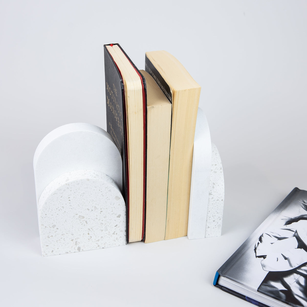 Quartz Bookend Set is 4cm thick. Styled with books. Available in Nougat partnered with Organic White by Caesarstone with chunky coarse-grained textures and neutral-coloured mineral chips, meets a clean white surface with subtly blended undertones, reflecting a natural appearance that is effortlessly chic. The perfect addition to your home decor, similar to marble bookends.