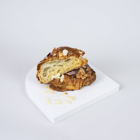Arch quartz serving platter in Caesarstone Aterra Blanca™ created by Aureliia Collection. Similar to a marble platter, the Arch Quartz platter shown with almond croissant. An excellent home decor gift for someone who has it all.
