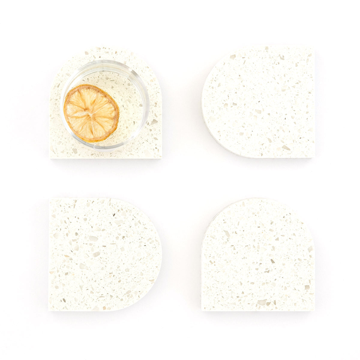 Quartz Arch Coaster™ Set 4 Piece in Nougat™. Quartz white stone coasters in an arch shape. These white quartz coasters are specked with decorative quartz with a cork backing. White marble coasters in appearance however quartz has greater scratch resistance and is lower maintenance. caesarstone quartz