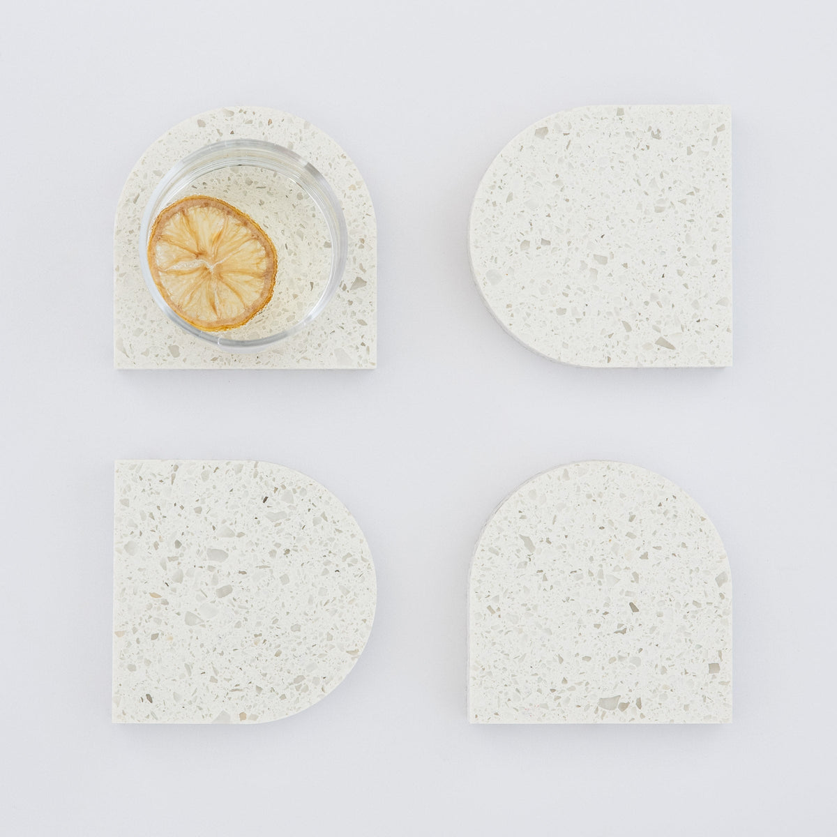 Quartz Arch Coaster™ Set 4 Piece in Nougat™. Quartz white stone coasters in an arch shape. These white quartz coasters are specked with decorative quartz with a cork backing. White marble coasters in appearance however quartz has greater scratch resistance and is lower maintenance. caesarstone quartz